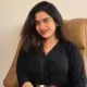 A girl is sitting in the picture and smiling.