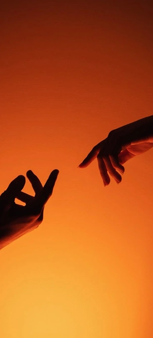 Silhouette of two hands reaching toward each other.